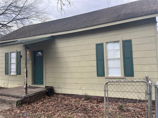 436 N Pine St, Waldron, AR 72958 - view of side of home with a shingled roof and fence