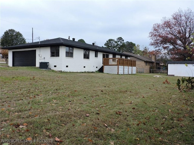 back of house with a garage, a deck, a yard, and central AC