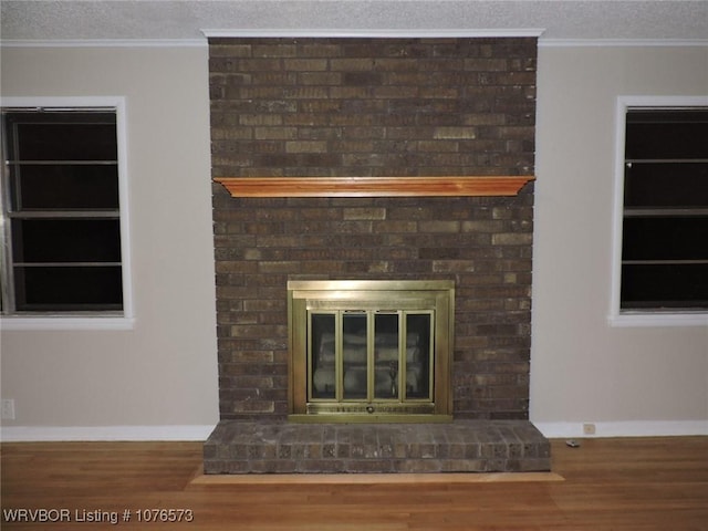 details with hardwood / wood-style flooring, crown molding, and a brick fireplace