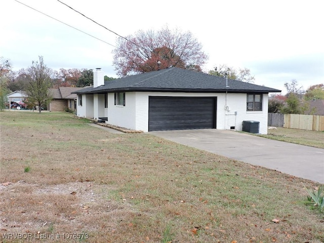 view of front of home featuring cooling unit, a garage, and a front yard