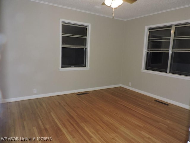 spare room featuring hardwood / wood-style flooring, ceiling fan, and crown molding