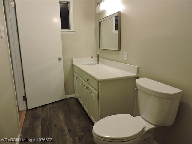 bathroom with hardwood / wood-style floors, vanity, and toilet