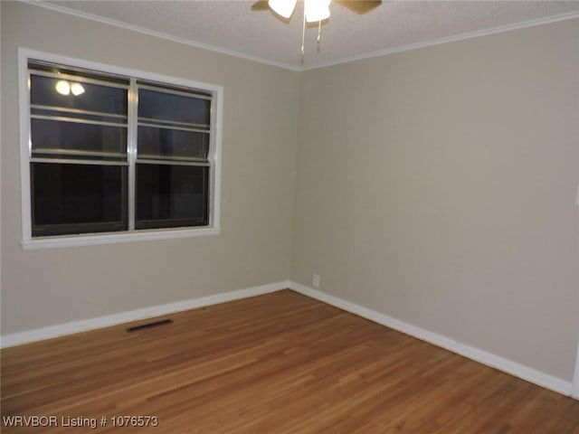 empty room featuring hardwood / wood-style flooring, ceiling fan, and crown molding