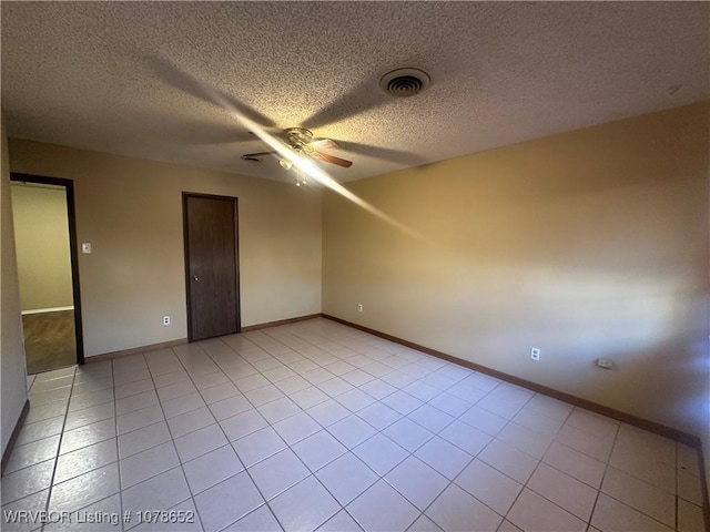 unfurnished room with light tile patterned floors, a textured ceiling, and ceiling fan