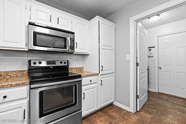 kitchen with white cabinets, dark stone countertops, and appliances with stainless steel finishes