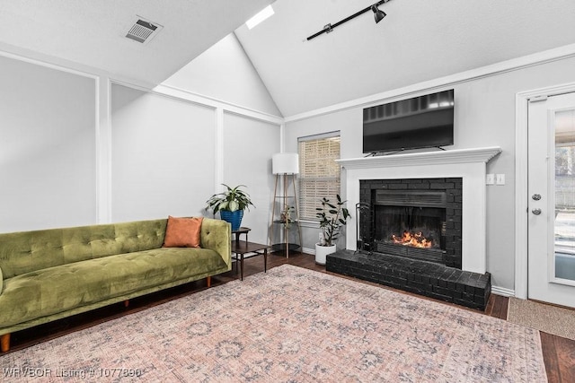 living room featuring a fireplace, hardwood / wood-style floors, and vaulted ceiling