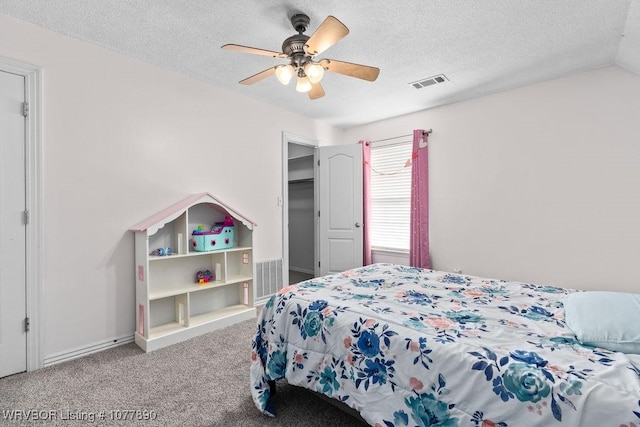 carpeted bedroom with ceiling fan and a textured ceiling