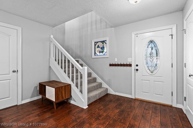 foyer with dark wood-type flooring and a textured ceiling