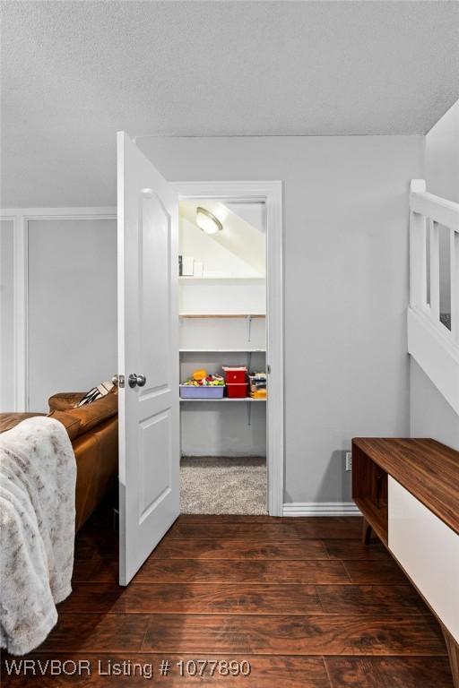 bedroom featuring dark hardwood / wood-style flooring and a textured ceiling