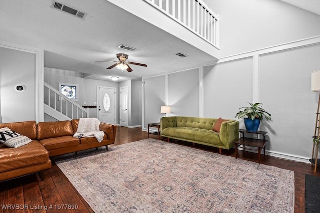 living room featuring ceiling fan and dark wood-type flooring