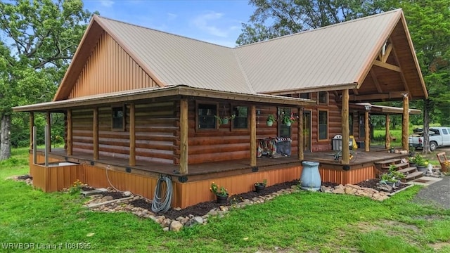 161129 N 4550th Rd, Talihina, OK 74571 - view of home's exterior featuring log exterior, a metal roof, covered porch, and a lawn