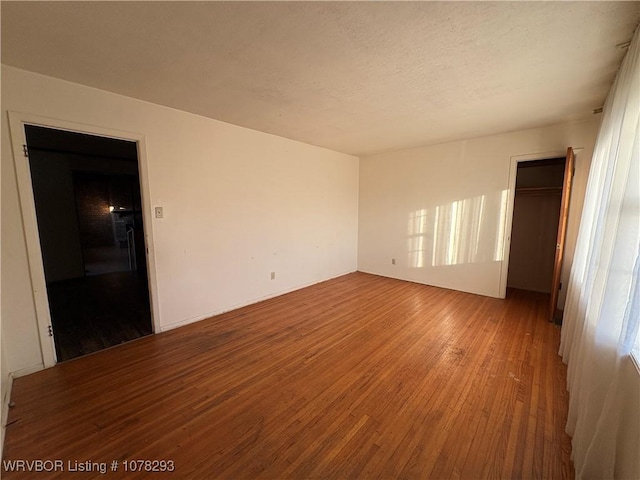 unfurnished room with hardwood / wood-style flooring