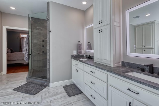 ensuite bathroom featuring a stall shower, double vanity, a sink, and ensuite bathroom