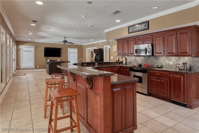 kitchen with appliances with stainless steel finishes, light tile patterned flooring, ornamental molding, and visible vents