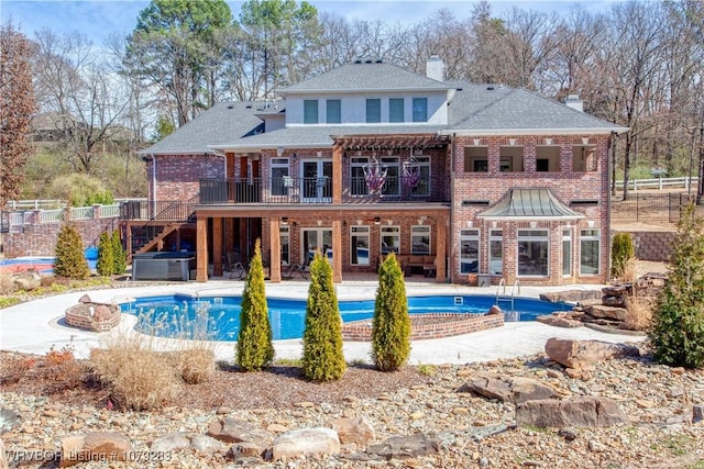 rear view of house with brick siding, fence, stairway, and a patio