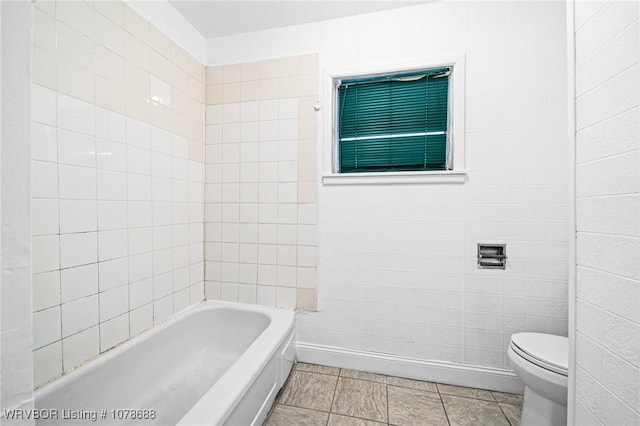 bathroom featuring a bath, tile patterned floors, and toilet