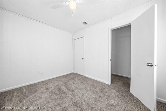 unfurnished bedroom with ceiling fan, carpet flooring, and a textured ceiling