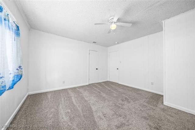 carpeted spare room with ceiling fan and a textured ceiling