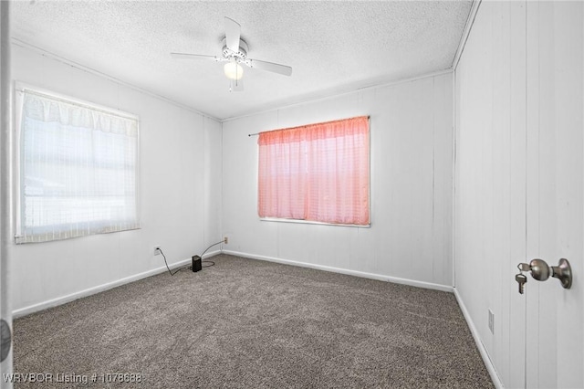 spare room featuring ceiling fan, a textured ceiling, and dark colored carpet