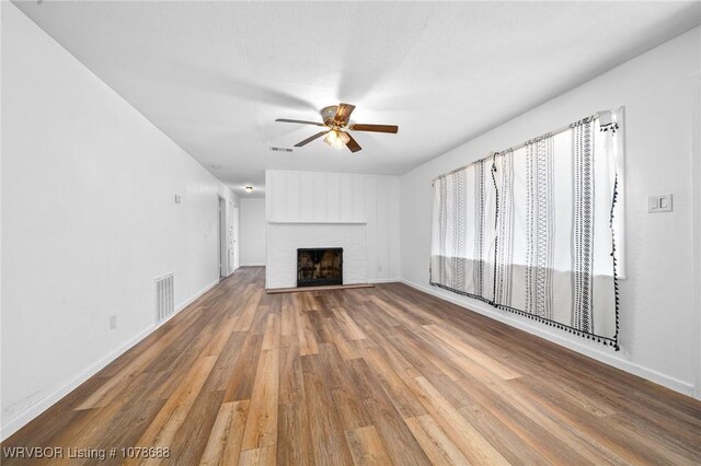 unfurnished living room featuring hardwood / wood-style flooring, a fireplace, and ceiling fan