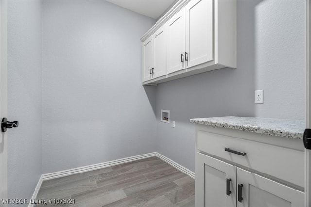 washroom featuring cabinets, washer hookup, and light wood-type flooring