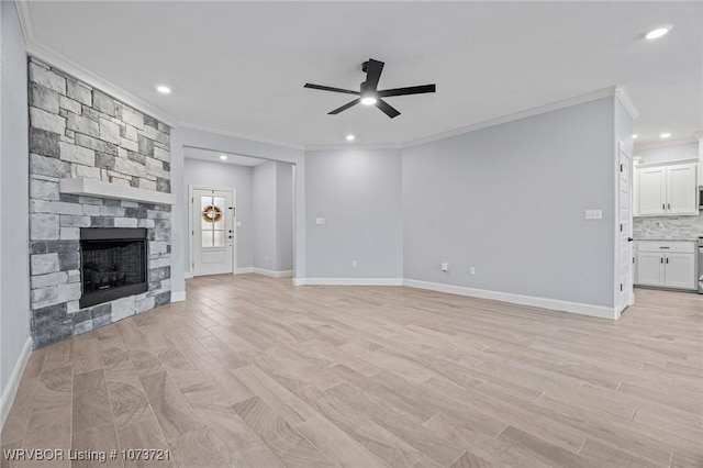 unfurnished living room featuring a stone fireplace, ceiling fan, and ornamental molding