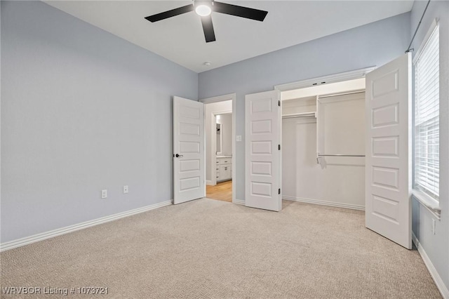 unfurnished bedroom featuring multiple windows, a closet, ceiling fan, and light colored carpet