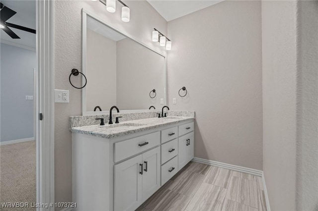 bathroom with ceiling fan, vanity, and ornamental molding