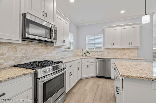 kitchen with backsplash, sink, white cabinets, and appliances with stainless steel finishes