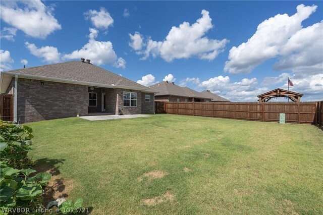 back of house featuring a lawn and a patio