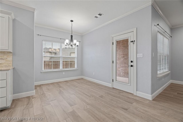 unfurnished dining area featuring an inviting chandelier, light hardwood / wood-style floors, and ornamental molding