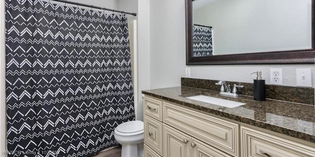 bathroom featuring a shower with shower curtain, vanity, and toilet