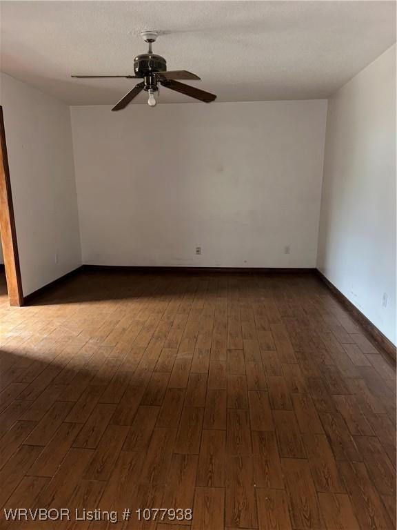 unfurnished room with dark hardwood / wood-style flooring and ceiling fan