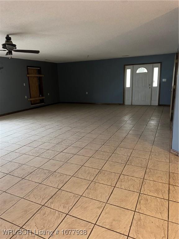 interior space with a textured ceiling and ceiling fan