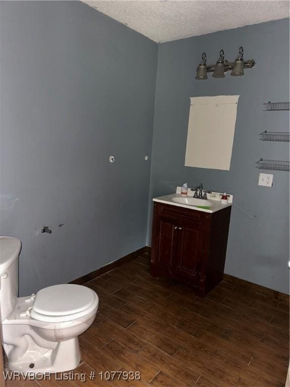 bathroom featuring vanity, a textured ceiling, and toilet