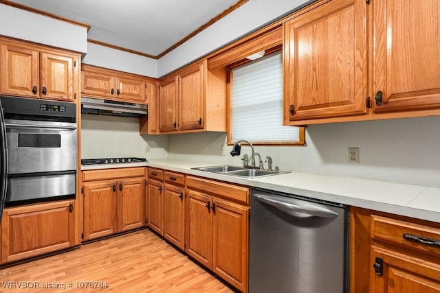 kitchen with crown molding, stainless steel appliances, sink, and light wood-type flooring