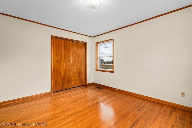 empty room featuring crown molding and light hardwood / wood-style floors