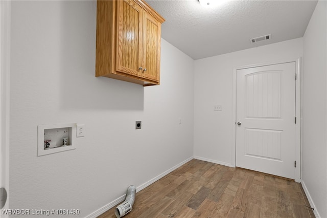 8601 Corona Ct, Uniontown, AR 72955 - laundry room with cabinet space, electric dryer hookup, hookup for a washing machine, wood finished floors, and a textured ceiling
