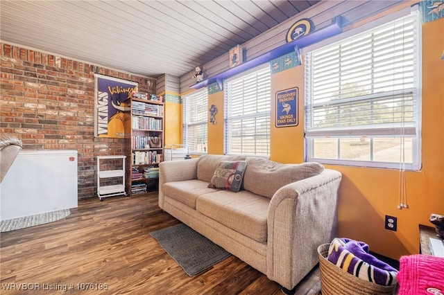 living room with wood ceiling, plenty of natural light, brick wall, and wood-type flooring