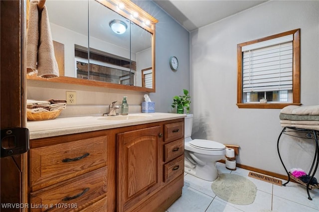 bathroom featuring tile patterned flooring, vanity, toilet, and a shower with door