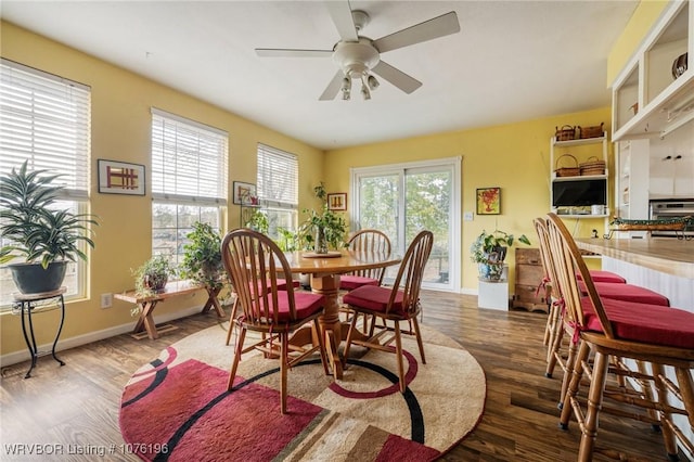 dining area featuring ceiling fan and dark wood-type flooring