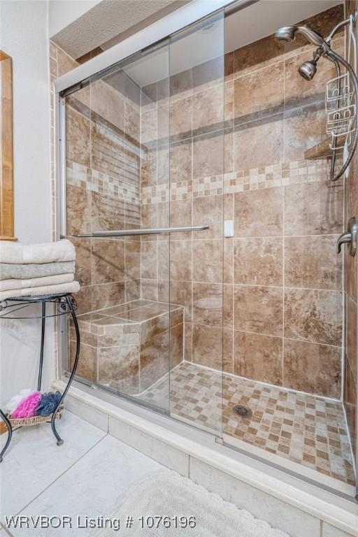 bathroom with tile patterned flooring and walk in shower