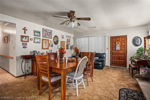 dining area with light carpet, a textured ceiling, and ceiling fan