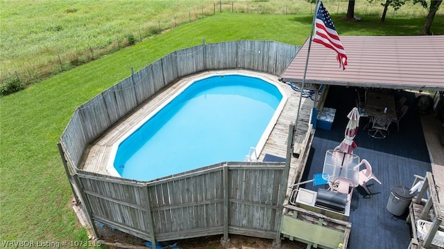 view of swimming pool with a lawn