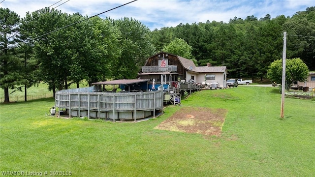 back of house featuring a pool side deck and a lawn