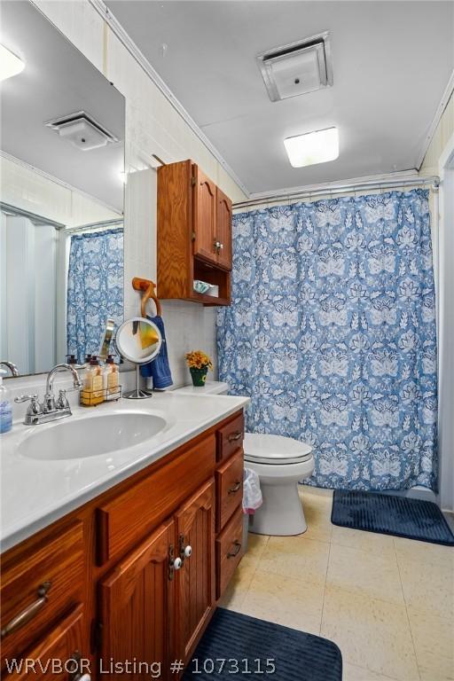 bathroom featuring a shower with curtain, vanity, toilet, and crown molding