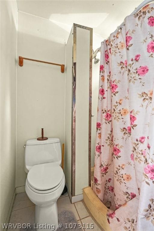 bathroom featuring toilet, tile patterned floors, and walk in shower