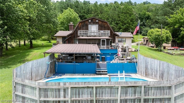 view of dock featuring a lawn, a balcony, and a fenced in pool