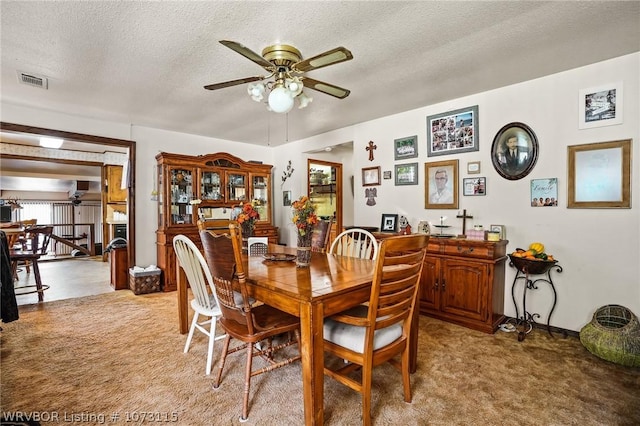 dining room with carpet, a textured ceiling, and ceiling fan