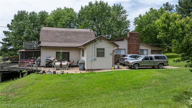 rear view of house featuring a yard, a deck, and a sunroom